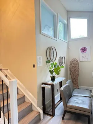 a living room with a chair and stairs at Banff mountain House&30 second Bus station Close C-Train& Free Parking in Calgary