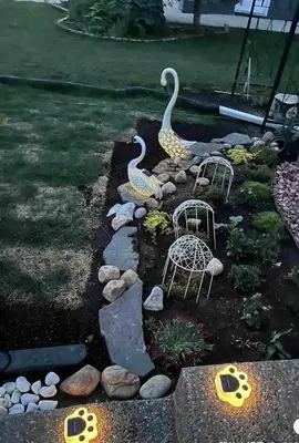 two swan statues in a garden with rocks at Banff Garden Suite&2mins Bus station Close LRT& Free Parking in Calgary