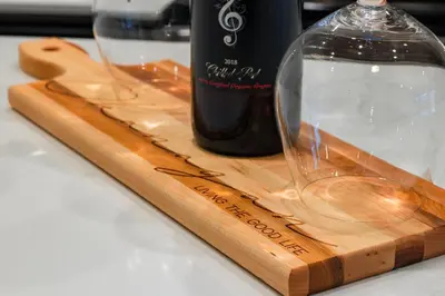 a bottle of wine and a glass on a wooden cutting board at Vita Resort Vernon on Lake Okanagan in Vernon
