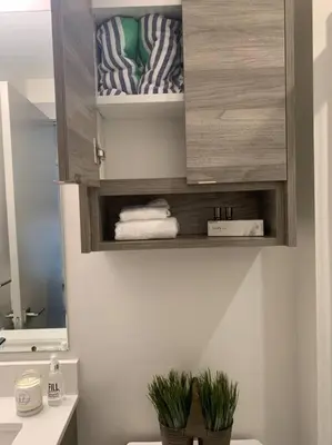 a bathroom with a cabinet with towels and plants at Vita Resort Vernon on Lake Okanagan in Vernon