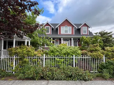 a white fence in front of a house at Mae Sweet Home in Surrey