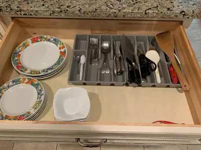 a drawer with plates and utensils in a kitchen at Mae Sweet Home in Surrey