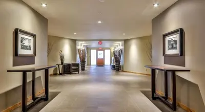 a hallway with two tables in a lobby at Luxurious Rundle Cliffs Lodge in Spring Creek in Canmore