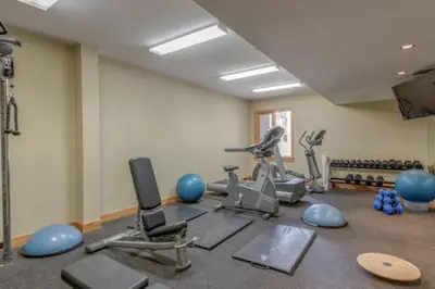 a gym with exercise equipment in a room at Luxurious Rundle Cliffs Lodge in Spring Creek in Canmore