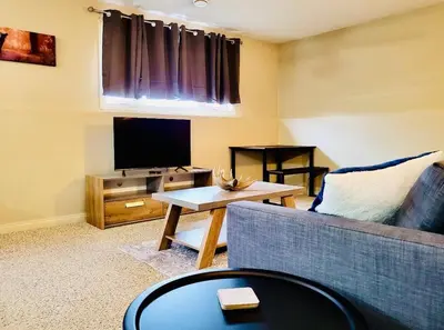 a living room with a couch and a tv at Spacious Basement suite in Camrose