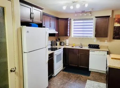 a kitchen with a white refrigerator and wooden cabinets at Spacious Basement suite in Camrose
