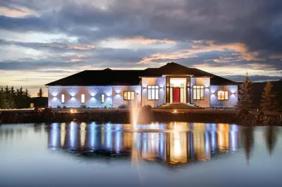 a house with lights on the water at night at Carbon Valley Ranch in Grainger