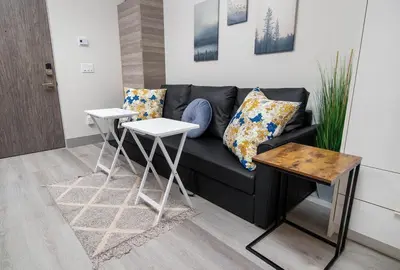 a living room with a black couch and two tables at Top Floor on Okanagan Lake with AC & Heated Pool in Vernon