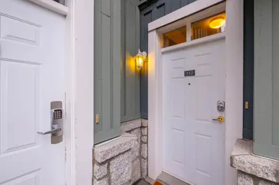 a white door with a window on a house at Granite Court by Outpost Whistler in Whistler