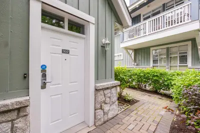 a white door of a house with a balcony at Granite Court by Outpost Whistler in Whistler