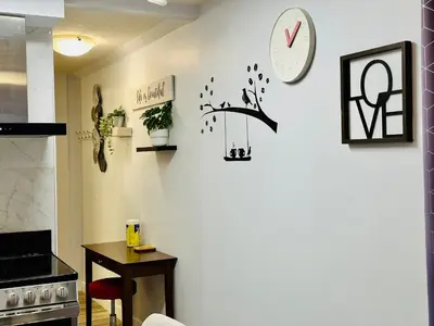 a kitchen with a table and a clock on the wall at Romantic Studio with Kitchen & AC & BBQ & a Huge Balcony 164 in Canmore