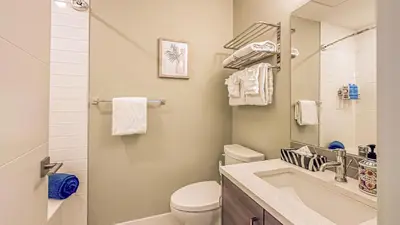 a bathroom with a sink and a toilet and a mirror at Skyline Escape - Mountain Views - Hot Tub - Pool in Canmore