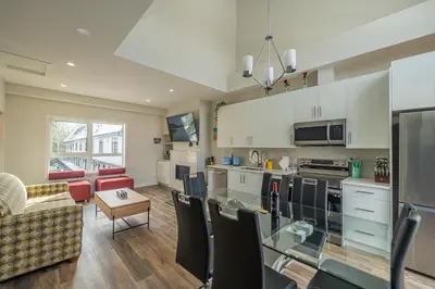 a kitchen and living room with a couch and a table at Skyline Escape - Mountain Views - Hot Tub - Pool in Canmore