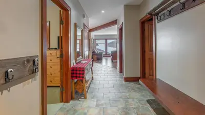 a hallway with a table in the middle of a room at Mountain Time - Spacious w Private Hot Tub and an Amazing View in Big White