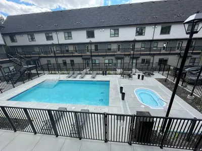 a building with a swimming pool in front of a building at Skyline Soak - Pool & Hot Tub & Mountain Views in Canmore