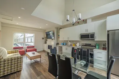 a kitchen and living room with a couch and a table at Skyline Soak - Pool & Hot Tub & Mountain Views in Canmore