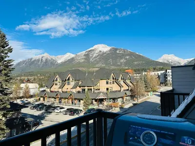 a view from the balcony of a resort with mountains at Skyline Soak - Pool & Hot Tub & Mountain Views in Canmore