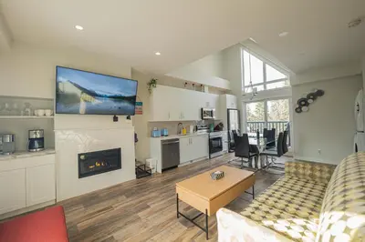 a living room with a couch and a fireplace at Skyline Soak - Pool & Hot Tub & Mountain Views in Canmore