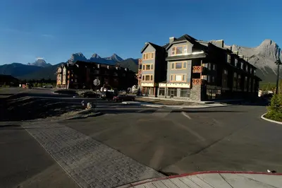 a large building on a street with mountains in the background at Apartment 405 Bear Creek Crossing in Canmore