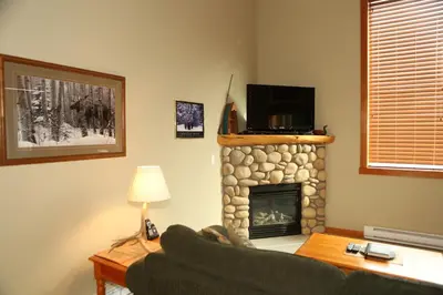 a living room with a couch and a fireplace at Apartment 405 Bear Creek Crossing in Canmore