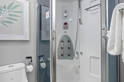a small bathroom with a shower and a toilet at Nature's Nook by Instant Suites Pool & HotTub in Canmore