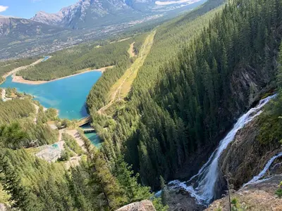 a view of a waterfall and a river in a forest at Mountain View Escape with Private Hot Tub & Patio in Canmore