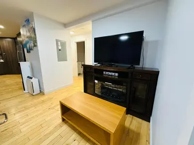 a living room with a flat screen tv on a cabinet at Mountain View Escape with Private Hot Tub & Patio in Canmore