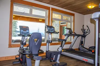 a gym with two treadmills and two exercise bikes at Jollymore Ranch in Smithers
