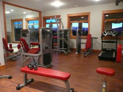 a gym with red chairs and equipment in a room at Jollymore Ranch in Smithers