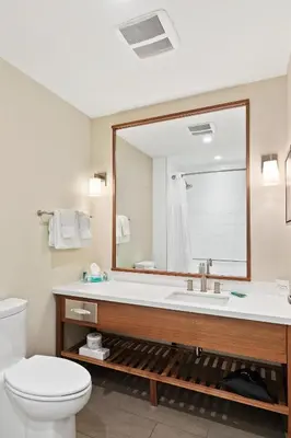 a bathroom with a sink and a toilet and a mirror at Mountain View Inn & Suites in Sundre