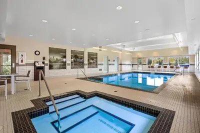 a large swimming pool in a large room with a pool at Mountain View Inn & Suites in Sundre