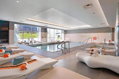 a room with a swimming pool with tables and chairs at Renaissance Edmonton Airport Hotel in Nisku