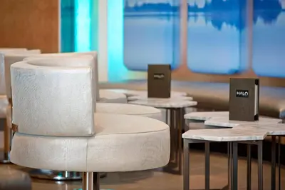 a row of tables with white chairs in a room at Renaissance Edmonton Airport Hotel in Nisku