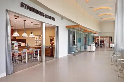 a store hallway with tables and chairs in a building at Renaissance Edmonton Airport Hotel in Nisku