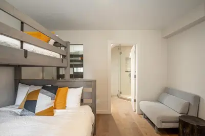 a bedroom with a bunk bed and a chair at 3BR in Snowgoose, Ski In, Luxury Property, Free Shuttle to Lifts, Parking in Whistler