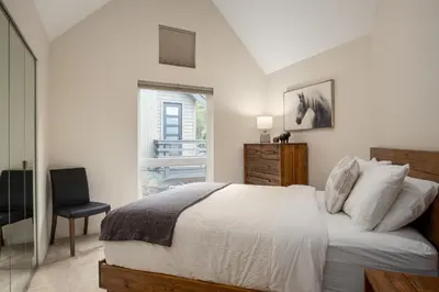 a bedroom with a bed and a chair and a window at 3BR in Snowgoose, Ski In, Luxury Property, Free Shuttle to Lifts, Parking in Whistler