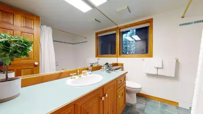 a bathroom with a sink and a toilet and a mirror at 2BR in Painted Cliff, Ski In, Ski Out, Communal Hot Tub, Wood Burning Fireplace, Free Parking in Whistler