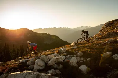 two people riding bikes on top of a mountain at 2BR in Painted Cliff, Ski In, Ski Out, Communal Hot Tub, Wood Burning Fireplace, Free Parking in Whistler