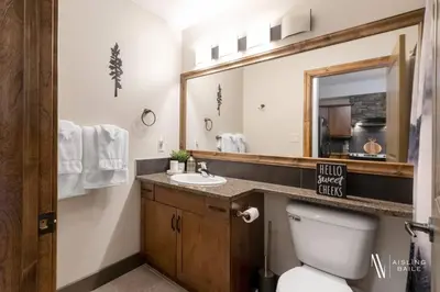 a bathroom with a toilet and a sink and a mirror at Heavenly Mountain Hideaway, Pool, Hot Tub in Radium Hot Springs
