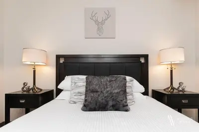 a bedroom with a large white bed with two lamps at Heavenly Mountain Hideaway, Pool, Hot Tub in Radium Hot Springs