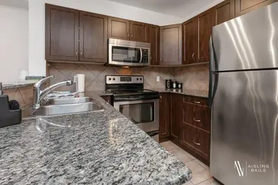 a kitchen with a stainless steel refrigerator and wooden cabinets at Chic Retreat, Modern, Pool, Hot Tub, Gym in Invermere