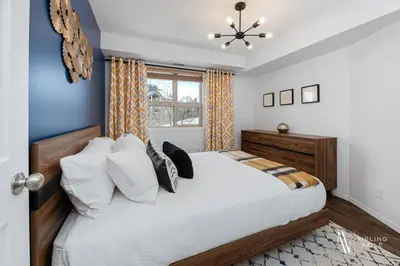 a bedroom with a large white bed and a window at Chic Retreat, Modern, Pool, Hot Tub, Gym in Invermere