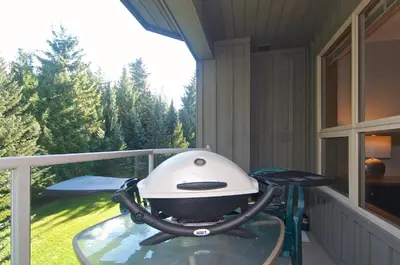 a grill sitting on a table on a balcony at Aspens on the Mountain Ski In Out in Whistler