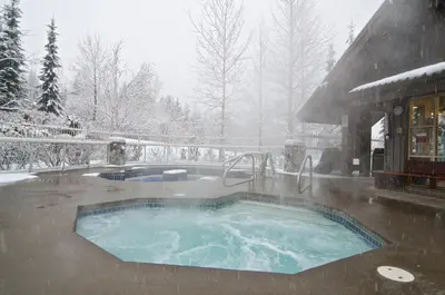 a jacuzzi tub in a snow covered yard at Aspens on the Mountain Ski In Out in Whistler