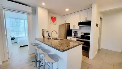 a kitchen with a counter and stools in a room at Beautiful 1 BR in the Heart of Downtown: Parking, Pool & Gym in Vancouver