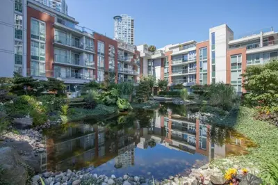 a garden in a city with buildings and a pond at Beautiful 1 BR in the Heart of Downtown: Parking, Pool & Gym in Vancouver