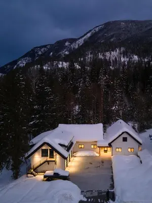 a house is covered in snow at night at Revelstoke Modern Farmhouse in Revelstoke