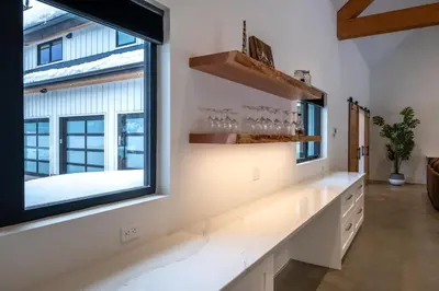 a room with a window and a counter with wine glasses at Revelstoke Modern Farmhouse in Revelstoke