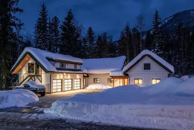 a house covered in snow at night at Revelstoke Modern Farmhouse in Revelstoke