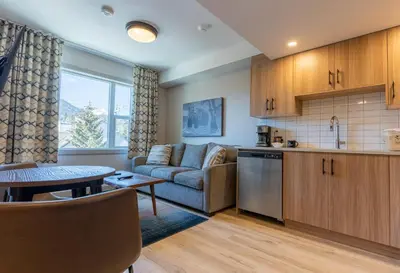 a kitchen and living room with a couch and a table at Basecamp Suites Banff in Banff